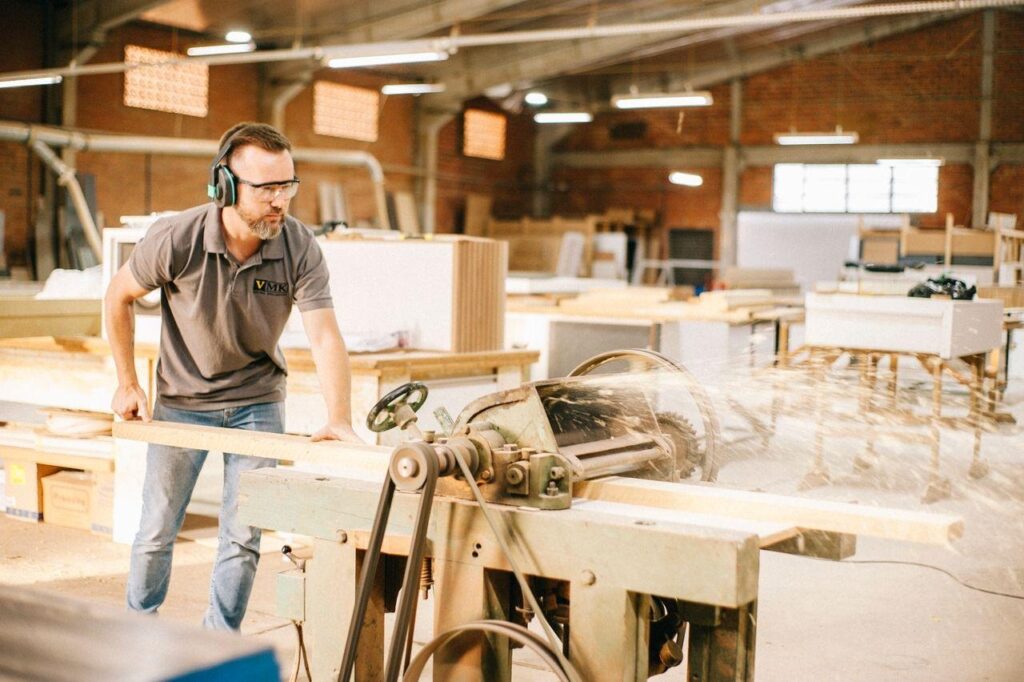 A carpenter working in a busy custom cabinet workshop