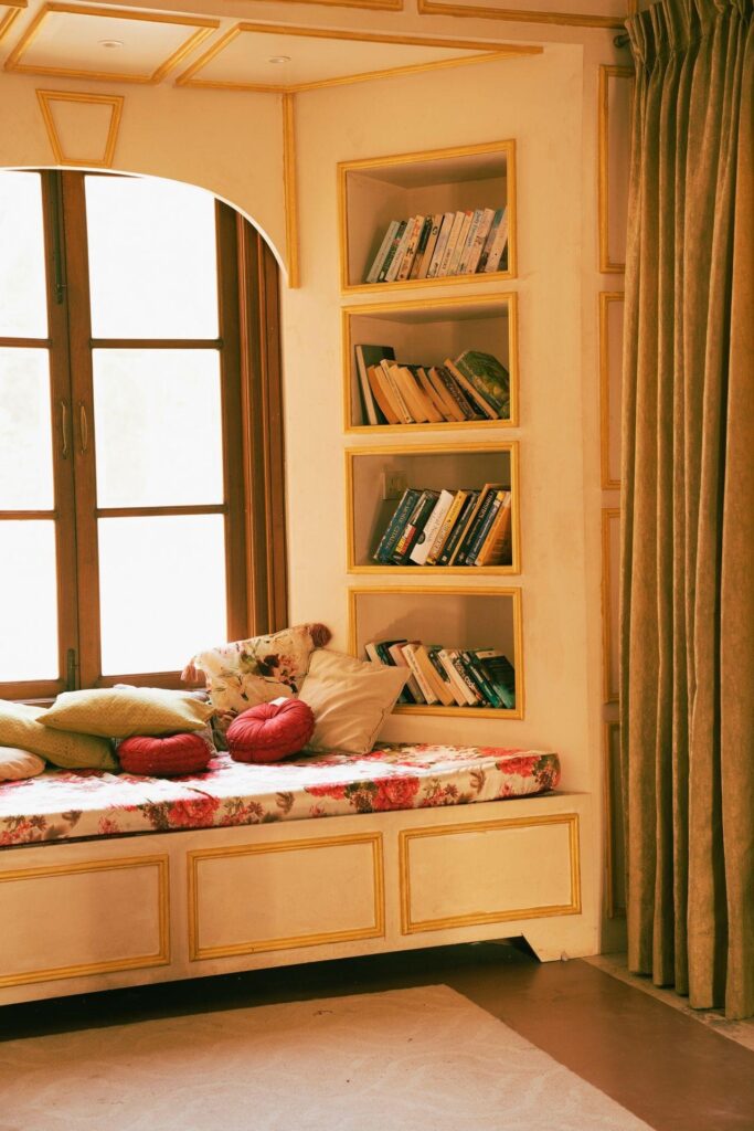 A built-in window seat with bookshelves in a bright home interior