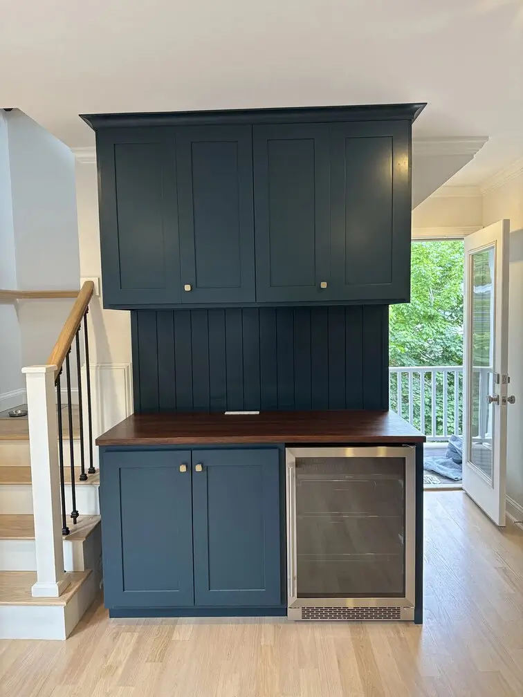 Custom blue kitchen pantry with beverage refrigerator, wood countertop, and built-in storage in Watertown home.